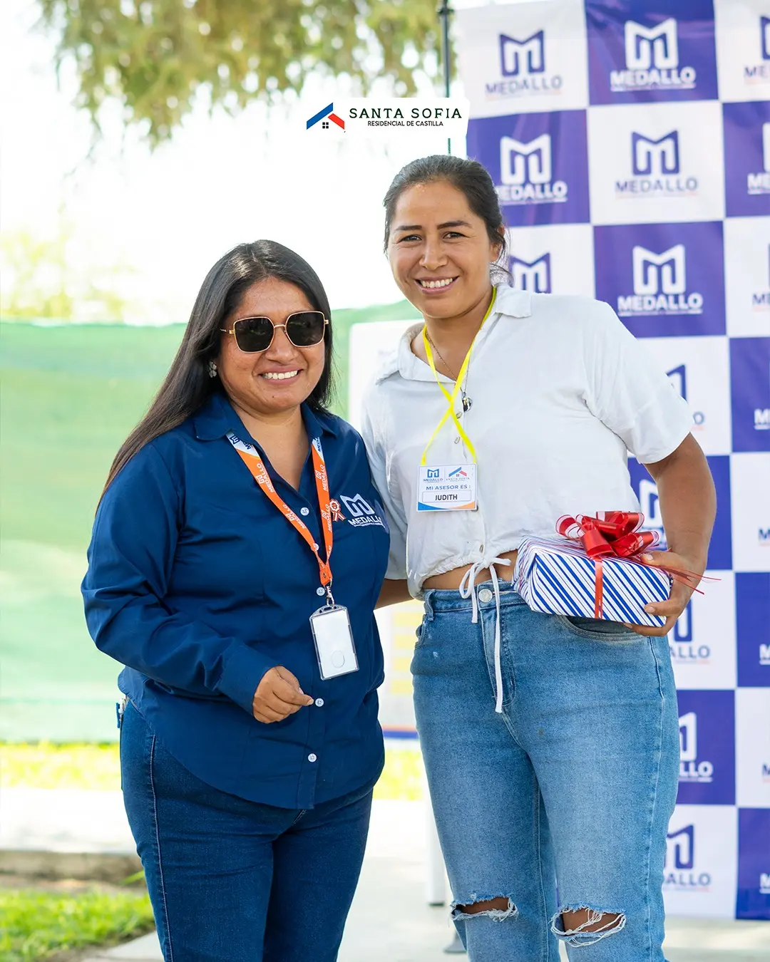 Dos clientas con un obsequio en el evento de Medallo, inmobiliaria de casas sin banco en Piura
